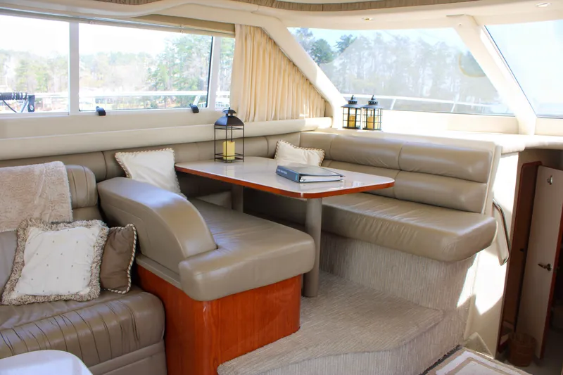 Slide: The Image of Luxurious interior of 1999 Sea Ray 480 Sedan Bridge yacht with plush seating and table. - 45