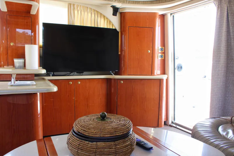 Slide: The Image of Luxurious interior of 1999 Sea Ray 480 Sedan Bridge yacht with TV and wooden cabinetry. - 48