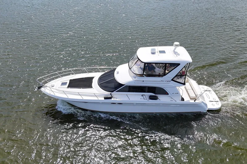 Slide: The Image of 1999 Sea Ray 480 Sedan Bridge cruising on open water, showcasing sleek design and spacious deck. - 6