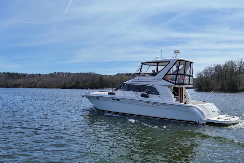 Slide: The Image of 1999 Sea Ray 480 Sedan Bridge yacht cruising on a serene lake. - 7