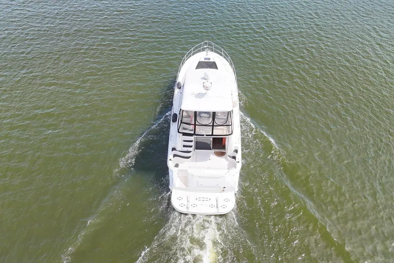 Slide: The Image of Aerial view of 1999 Sea Ray 480 Sedan Bridge yacht cruising on water. - 8