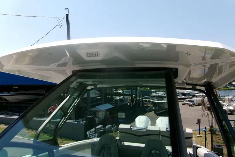 Slide: The Image of 2026 Monterey Elite 30 OB boat with sleek design and spacious seating at a marina. - 14