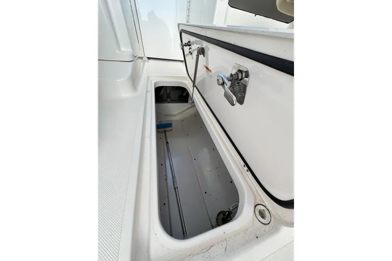 Slide: The Image of Open storage compartment on a 2015 Pursuit DC 265 Dual Console boat. - 10