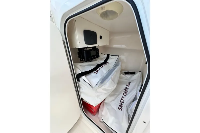 Slide: The Image of Storage compartment in 2015 Pursuit DC 265 Dual Console with safety gear bags. - 11