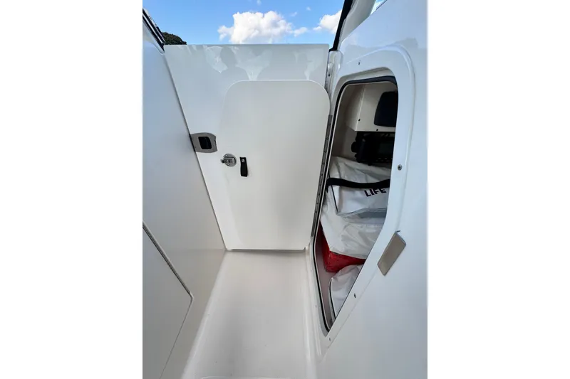 Slide: The Image of 2015 Pursuit DC 265 Dual Console boat interior storage compartment with life jackets. - 12