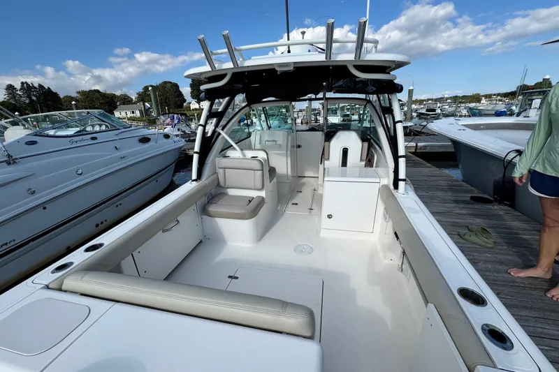 Slide: The Image of 2015 Pursuit DC 265 Dual Console boat docked, showcasing spacious seating and sleek design. - 3
