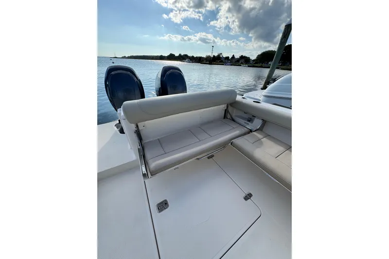 Slide: The Image of 2015 Pursuit DC 265 Dual Console boat with seating, docked by a serene waterfront. - 9