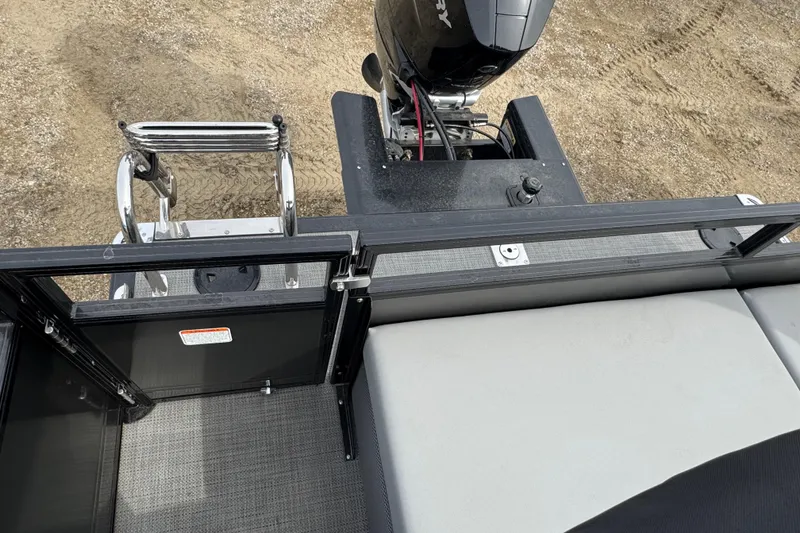 Slide: The Image of 2024 Regency 250 DL3 boat rear view with motor and ladder on a sandy surface. - 11