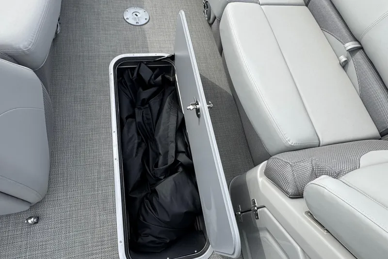 Slide: The Image of 2024 Regency 250 DL3 boat interior storage compartment with open lid and seating. - 13