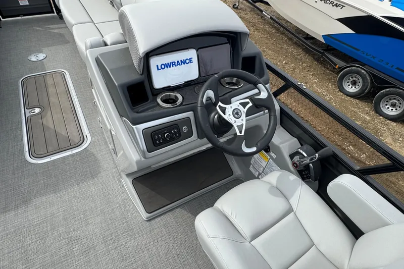 Slide: The Image of 2024 Regency 250 DL3 boat helm with Lowrance display and modern steering wheel. - 8