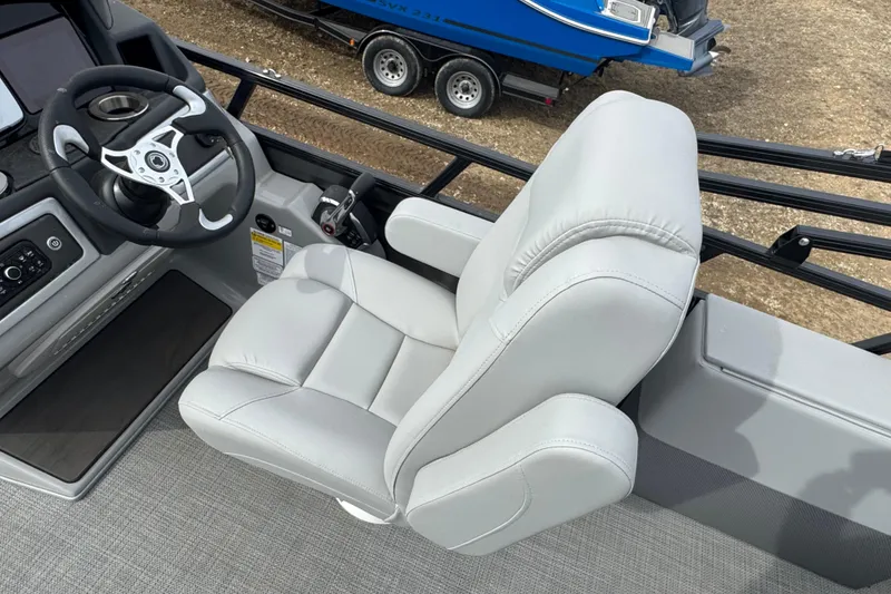 Slide: The Image of 2024 Regency 250 DL3 boat helm with plush captain's chair and modern steering wheel. - 9