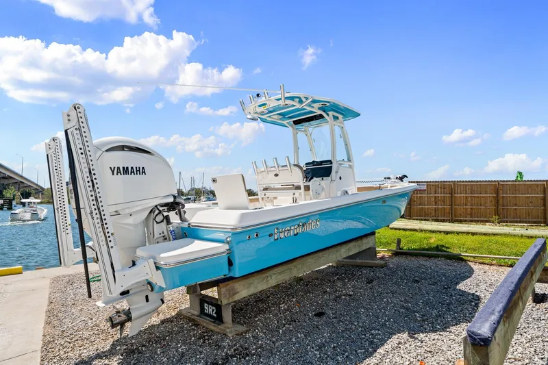 The Image of 2023 Everglades 243 Center Console boat with Yamaha engine, docked near a marina. - 1