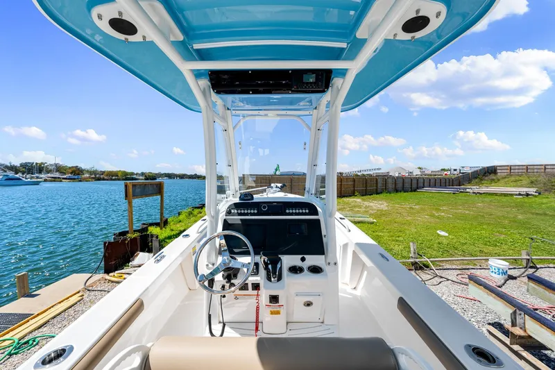 Slide: The Image of 2023 Everglades 243 Center Console boat docked by a scenic waterfront. - 10