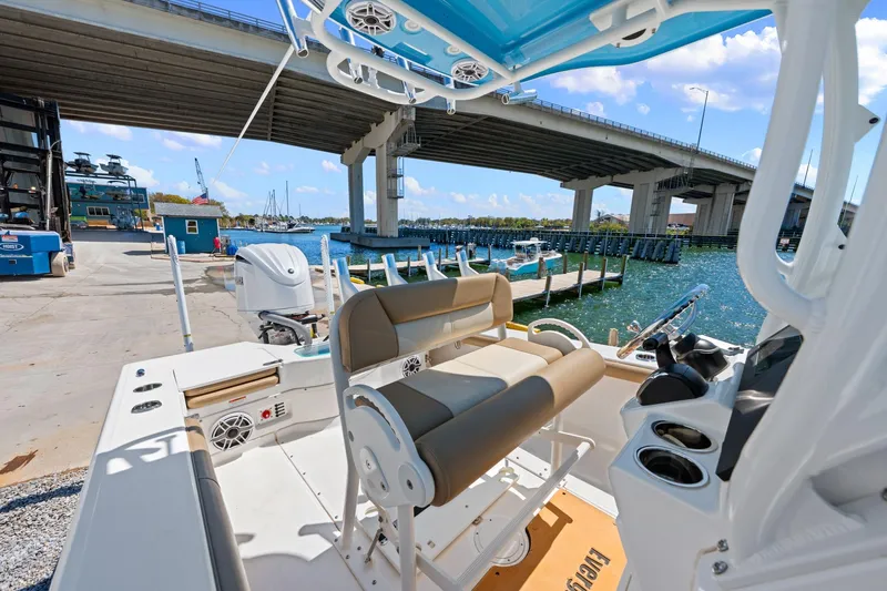 Slide: The Image of 2023 Everglades 243 Center Console boat docked under a bridge, sunny day. - 12