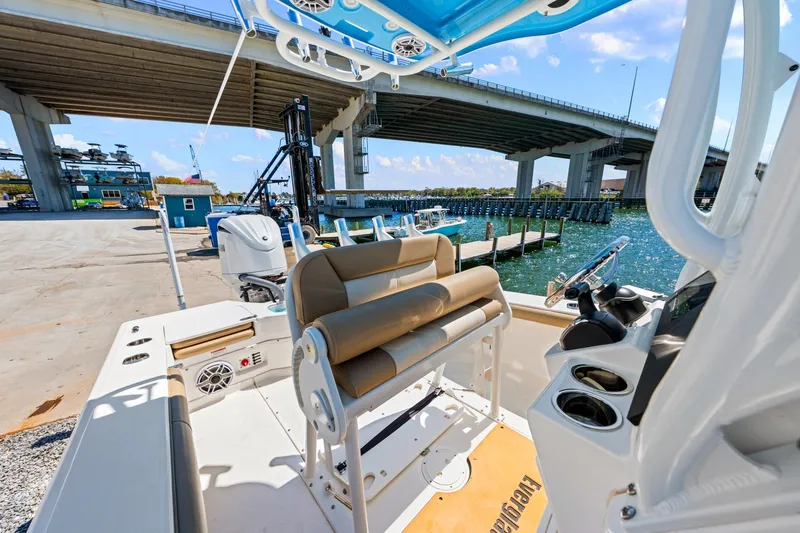 Slide: The Image of 2023 Everglades 243 Center Console boat docked near a bridge on a sunny day. - 13