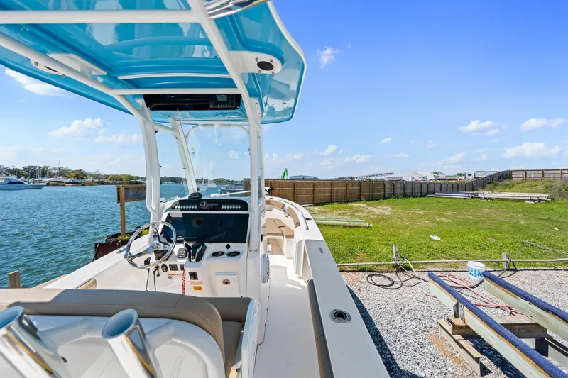 Slide: The Image of 2023 Everglades 243 Center Console boat docked by a scenic waterfront. - 14