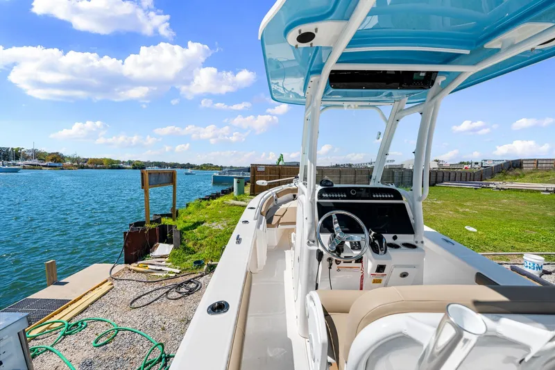 Slide: The Image of 2023 Everglades 243 Center Console boat docked by a scenic waterfront. - 17