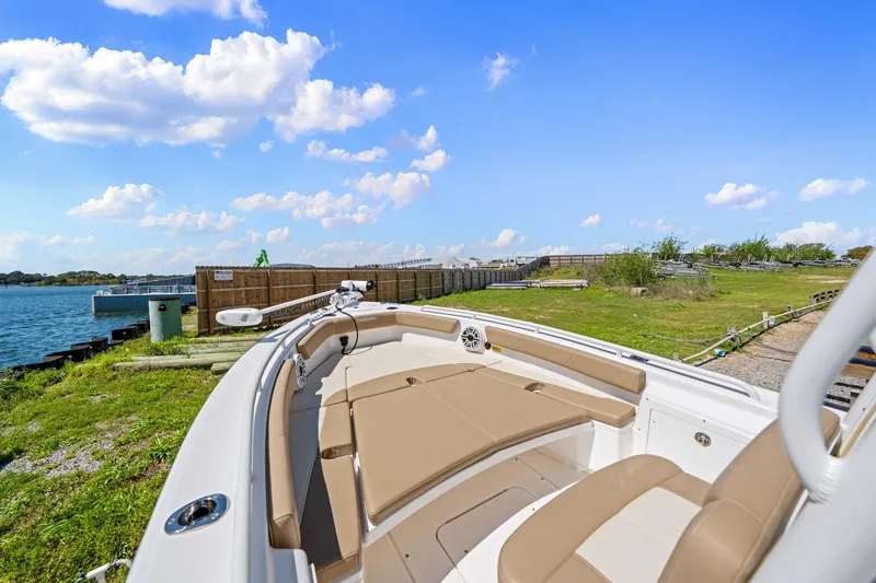 Slide: The Image of 2023 Everglades 243 Center Console boat docked by a scenic waterfront. - 19