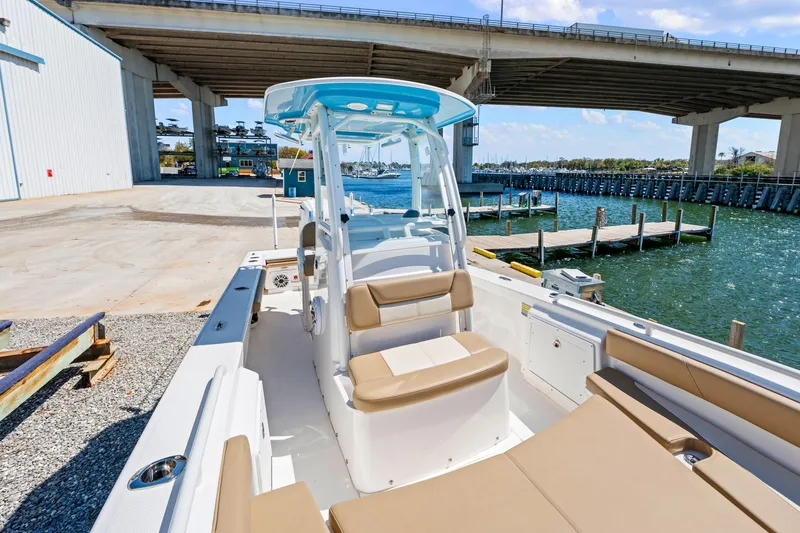 Slide: The Image of 2023 Everglades 243 Center Console boat docked near a bridge, showcasing seating and helm. - 21