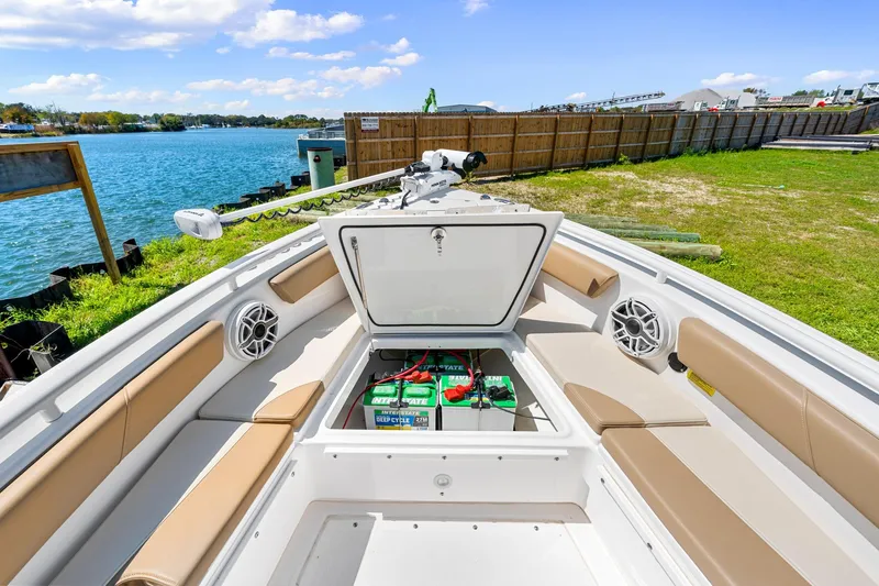 Slide: The Image of 2023 Everglades 243 Center Console boat with open storage compartment, docked by the water. - 26