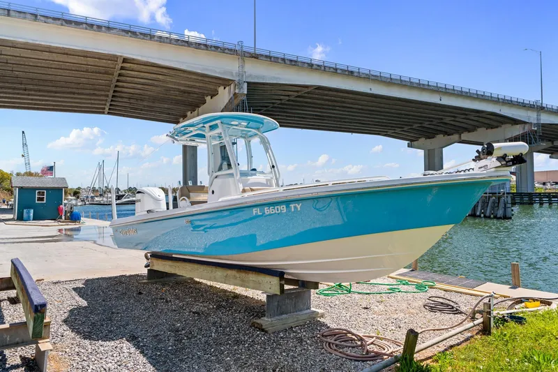 Slide: The Image of 2023 Everglades 243 Center Console boat docked under a bridge on a sunny day. - 3