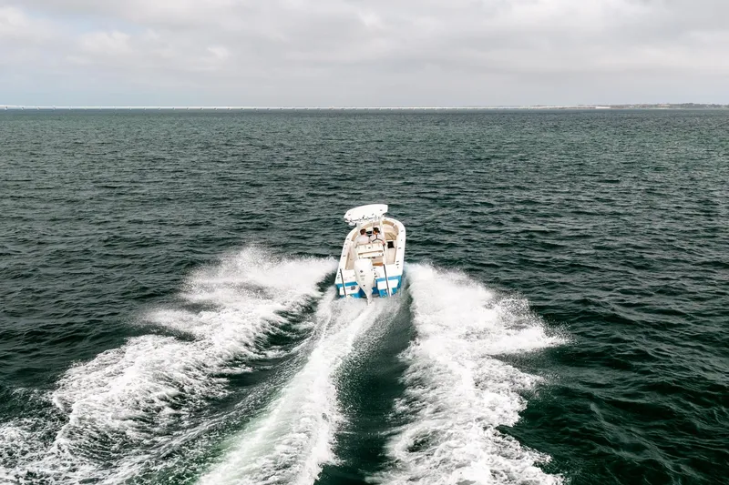 Slide: The Image of 2023 Everglades 243 Center Console boat cruising on open water, leaving a wake. - 32