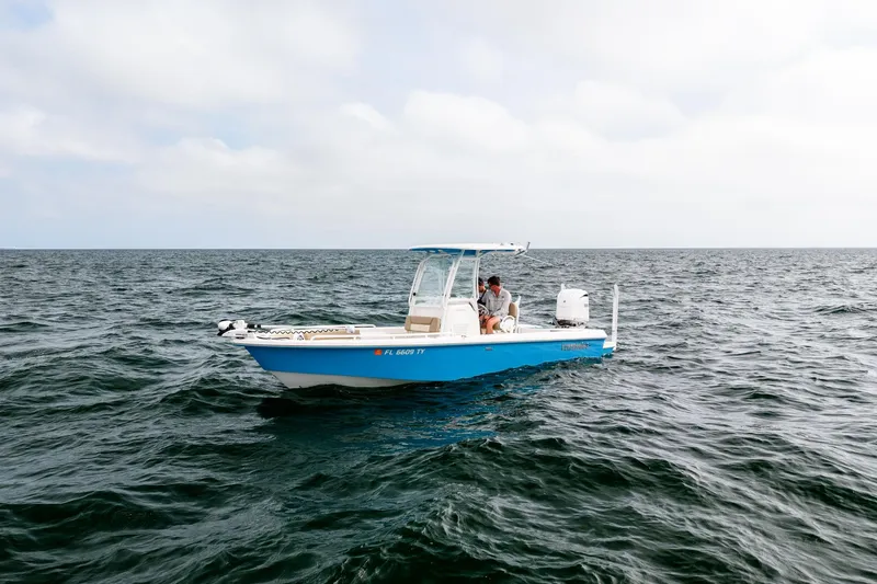 Slide: The Image of 2023 Everglades 243 Center Console boat on open water under cloudy sky. - 40