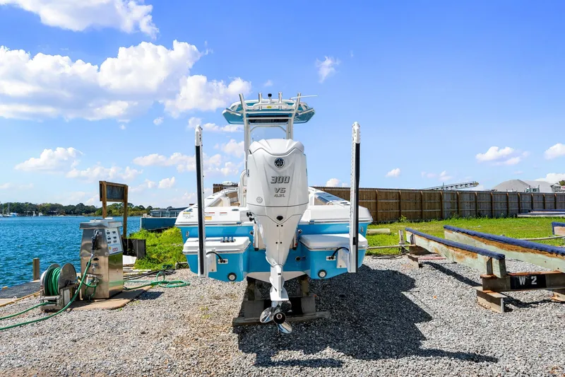 Slide: The Image of 2023 Everglades 243 Center Console boat docked by a scenic waterfront. - 5