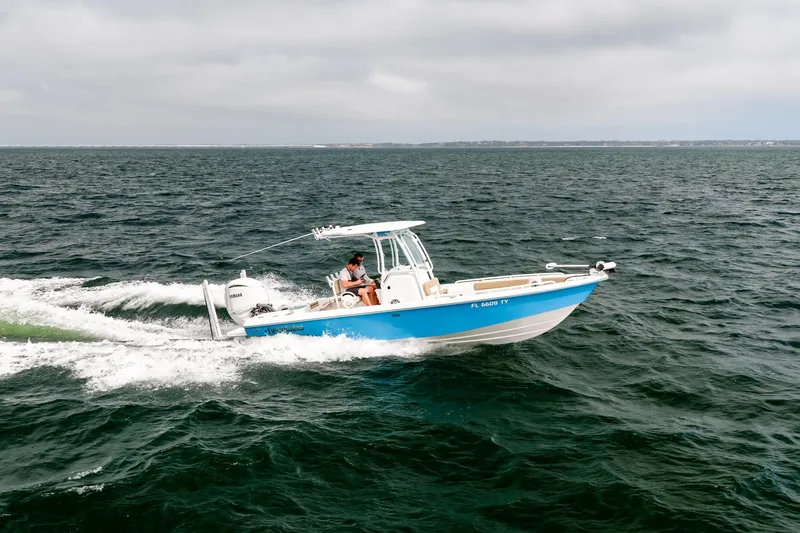 Slide: The Image of 2023 Everglades 243 Center Console boat cruising on open water. - 53
