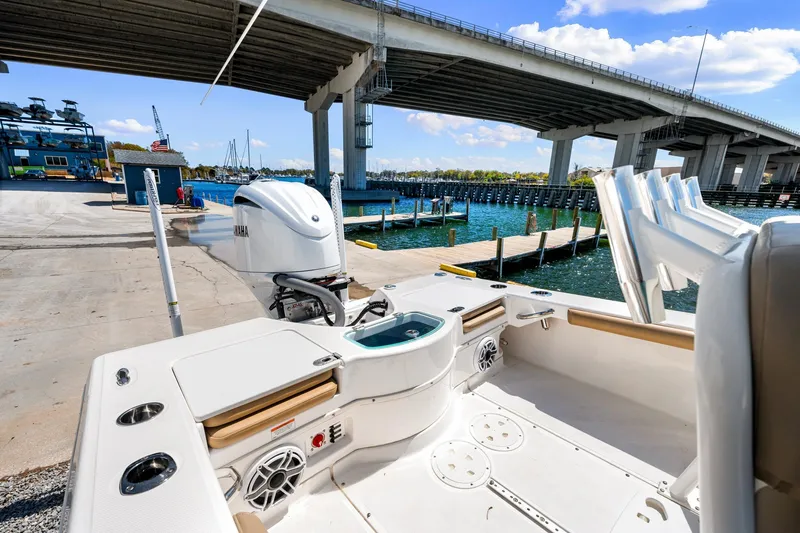 Slide: The Image of 2023 Everglades 243 Center Console boat docked under a bridge, showcasing its sleek design. - 7