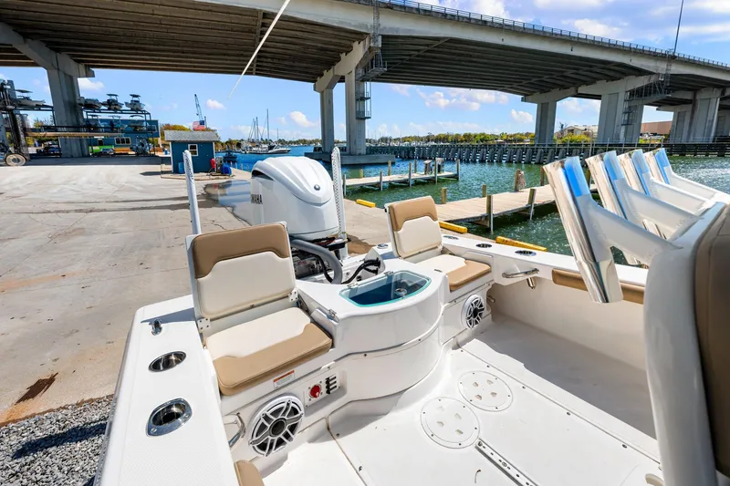 Slide: The Image of 2023 Everglades 243 Center Console boat docked under a bridge, showcasing seating and engine. - 8