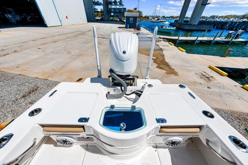 Slide: The Image of 2023 Everglades 243 Center Console boat at dock, showcasing rear deck and engine. - 9