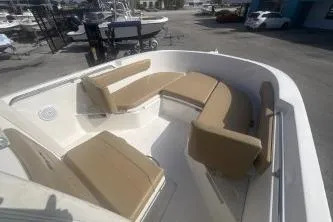 Slide: The Image of 2023 Bayliner Trophy T22CC boat with beige seating in a marina setting. - 10