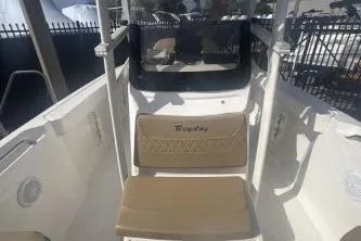Slide: The Image of 2023 Bayliner Trophy T22CC boat interior with tan seating and console. - 11