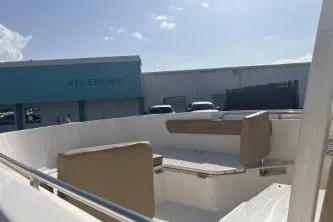 Slide: The Image of 2023 Bayliner Trophy T22CC boat interior with seating, docked near a receiving area. - 7