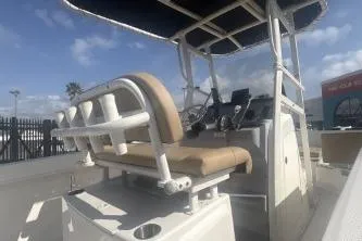 Slide: The Image of 2023 Bayliner Trophy T22CC boat interior with helm and seating under a blue sky. - 8