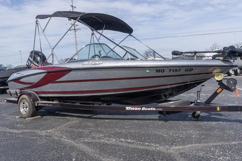 The Image of 2012 Triton 190 SE boat on trailer with canopy, parked outdoors. - 1