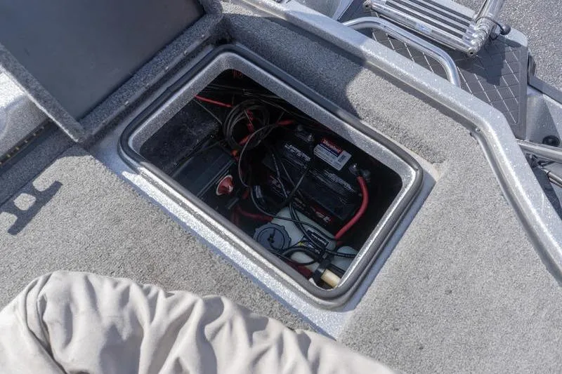 Slide: The Image of 2012 Triton 190 SE boat battery compartment with wiring and storage. - 22