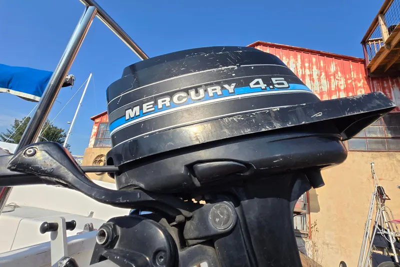 Slide: The Image of 1983 Tillotson-Pearson 21 Freedom boat with Mercury 4.5 outboard motor, docked outdoors. - 8