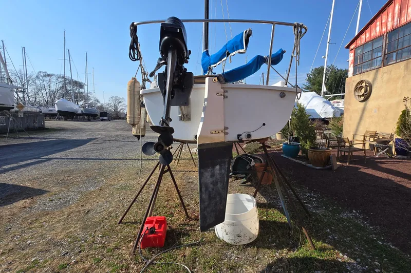 Slide: The Image of 1983 Tillotson-Pearson 21 Freedom sailboat on stands, with outboard motor, in a boatyard. - 9