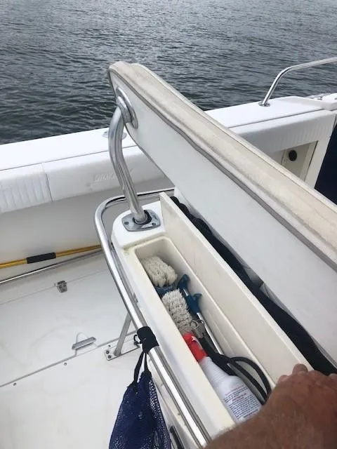 Slide: The Image of 1999 Boston Whaler Outrage 26 with open storage compartment on water. - 15