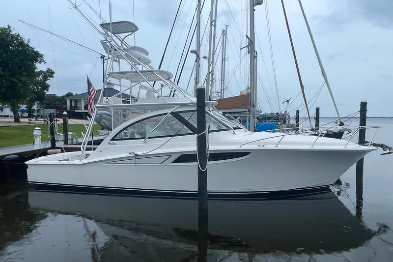 Slide: The Image of 2020 Mag Bay 42 yacht docked at marina, sleek design, overcast sky. - 2