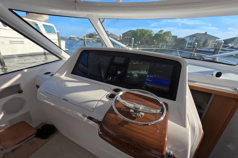Slide: The Image of Cockpit of 2020 Mag Bay 42 boat with modern navigation system and wooden steering wheel. - 26