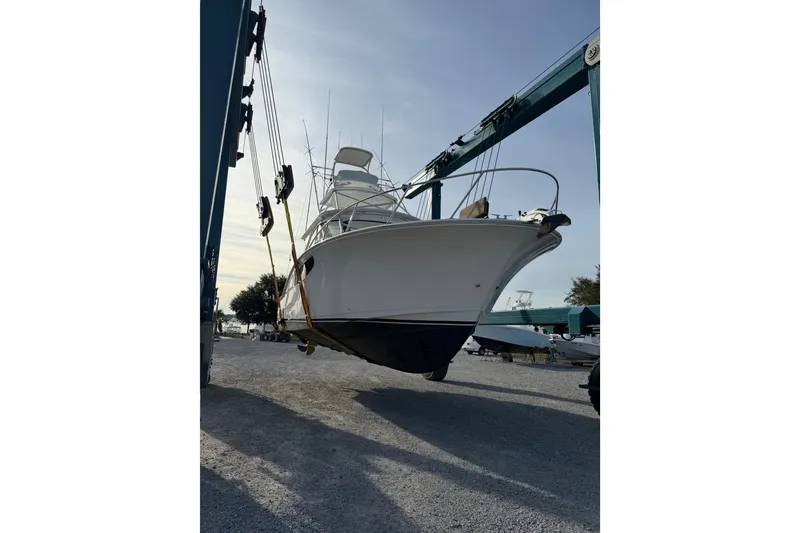 Slide: The Image of 2020 Mag Bay 42 boat lifted by crane in a marina setting. - 32