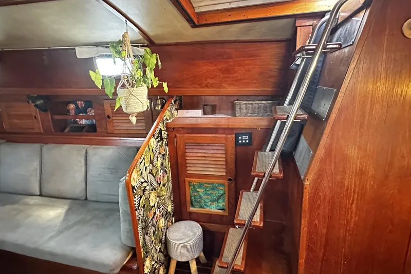 Slide: The Image of Interior of 1981 Pearson 424 sailboat with wooden finish, cozy seating, and hanging plant. - 15