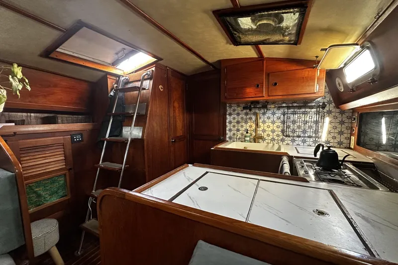 Slide: The Image of Interior of a 1981 Pearson 424 sailboat with wooden cabinetry and nautical decor. - 16