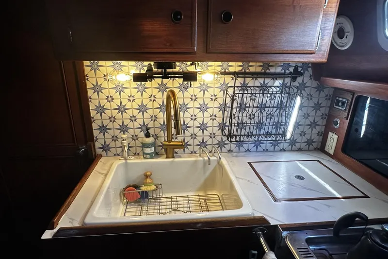 Slide: The Image of 1981 Pearson 424 yacht kitchen with star-patterned tiles and modern sink fixtures. - 18