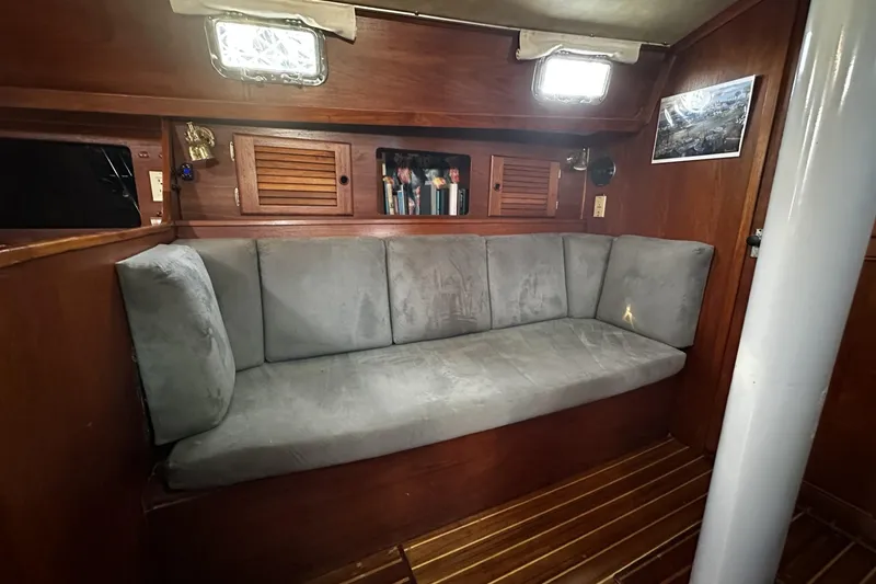 Slide: The Image of Cozy interior of 1981 Pearson 424 sailboat with cushioned seating and wooden cabinetry. - 21