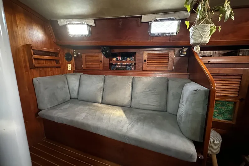 Slide: The Image of Cozy interior of 1981 Pearson 424 sailboat with cushioned seating and wooden cabinetry. - 22