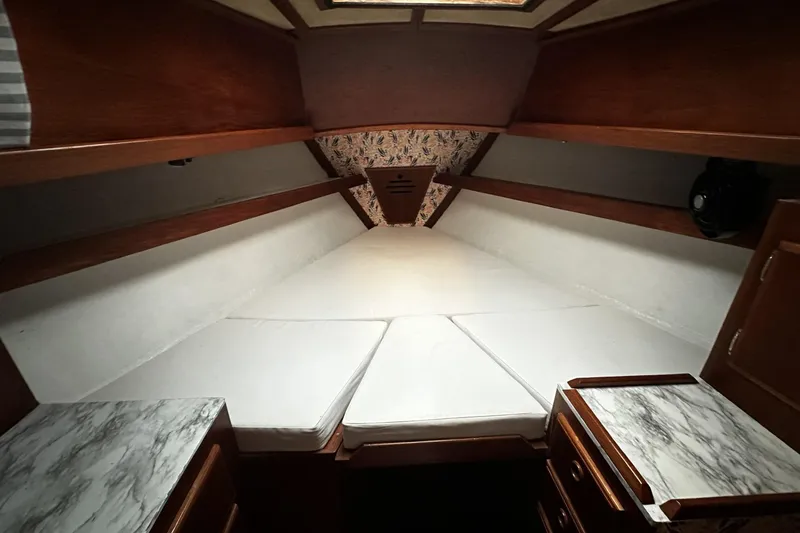 Slide: The Image of Interior cabin of a 1981 Pearson 424 sailboat with white cushions and wooden cabinetry. - 23